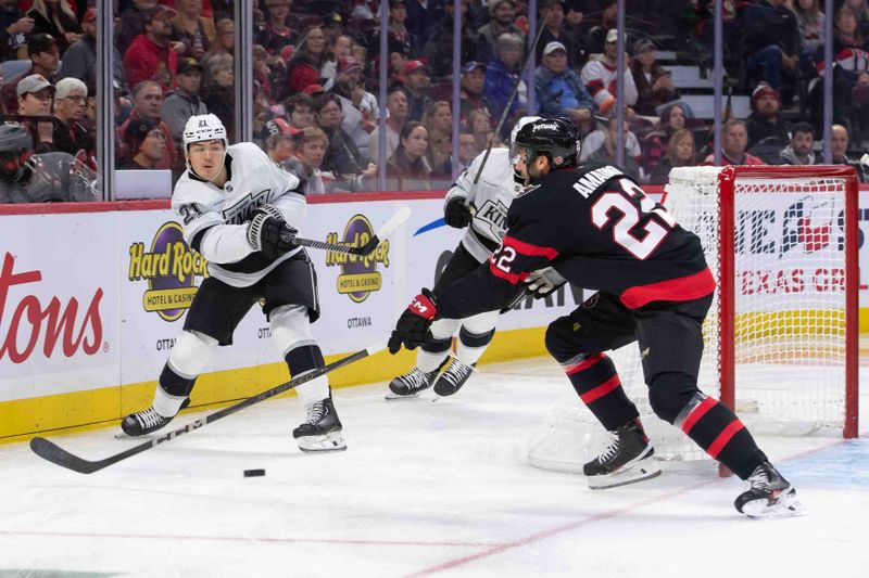 Oct 14, 2024; Ottawa, Ontario, CAN; Los Angeles Kings defenseman Jordan Spence shoots the puck as Ottawa Senators right wing Michael Amadia (22) skates up in the first period at the Canadian Tire Centre. Mandatory Credit: Marc DesRosiers-Imagn Images