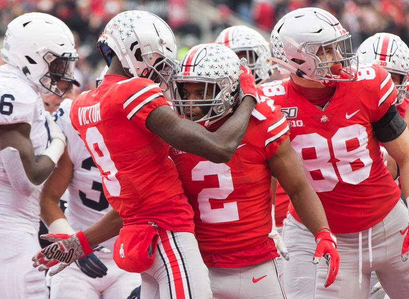 Nov 23, 2019; Columbus, OH, USA; Ohio State Buckeyes running back J.K. Dobbins (2) is congratulated by wide receiver Binjimen Victor (9) and tight end Jeremy Ruckert (88) after his first quarter touchdown against the Penn State Nittany Lions at Ohio Stadium. Mandatory Credit: Greg Bartram-USA TODAY Sports