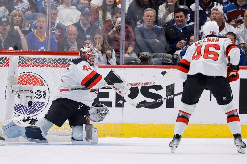 Nov 7, 2023; Denver, Colorado, USA; New Jersey Devils goaltender Vitek Vanecek (41) knocks the puck out of the air ahead of center Max Willman (46) in the third period at Ball Arena. Mandatory Credit: Isaiah J. Downing-USA TODAY Sports