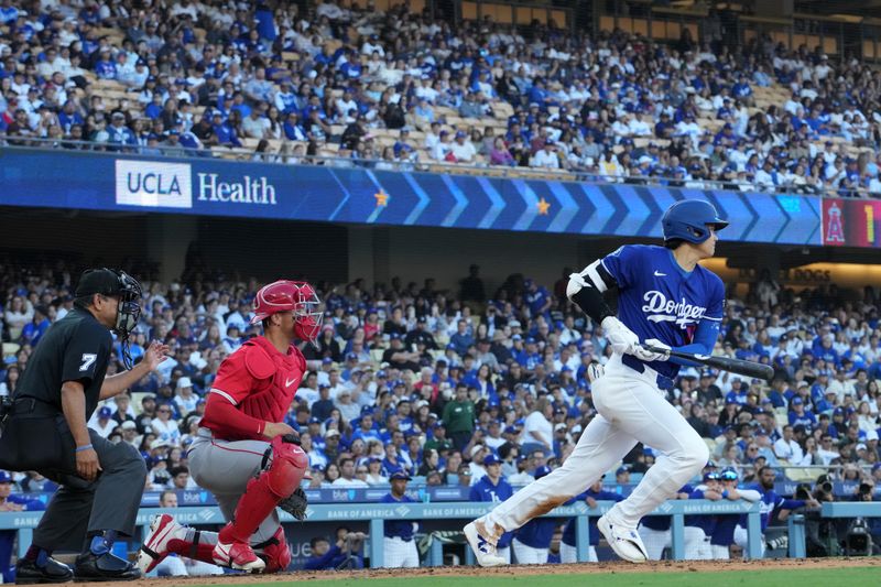 Mar 23, 2025; Los Angeles, California, USA; Los Angeles Dodgers two-way player Shohei Ohtani (17) bats in the fourth inning as Los Angeles Angels catcher Logan O'Hoppe (14) and home plate umpire Alfonso Marquez (72) watch at Dodger Stadium. Mandatory Credit: Kirby Lee-Imagn Images