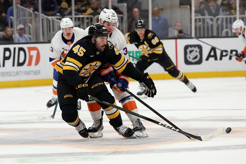 Oct 28, 2025; Boston, Massachusetts, USA; Boston Bruins defenseman Jonathan Aspirot (45) tries to keep the puck from New York Islanders center Kyle MacLean (32) during the second period at TD Garden. Mandatory Credit: Winslow Townson-Imagn Images
