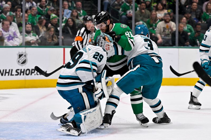 Nov 20, 2024; Dallas, Texas, USA; Dallas Stars center Tyler Seguin (91) collides with San Jose Sharks goaltender Mackenzie Blackwood (29) and defenseman Henry Thrun (3) during the second period at the American Airlines Center. Mandatory Credit: Jerome Miron-Imagn Images