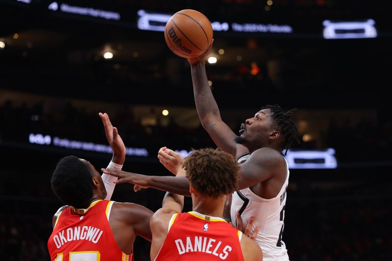 ATLANTA, GEORGIA - OCTOBER 23: Dorian Finney-Smith #28 of the Brooklyn Nets drives to the basket against Onyeka Okongwu #17 and Dyson Daniels #5 of the Atlanta Hawks during the second quarter at State Farm Arena on October 23, 2024 in Atlanta, Georgia. NOTE TO USER: User expressly acknowledges and agrees that, by downloading and or using this photograph, User is consenting to the terms and conditions of the Getty Images License Agreement. (Photo by Kevin C. Cox/Getty Images)