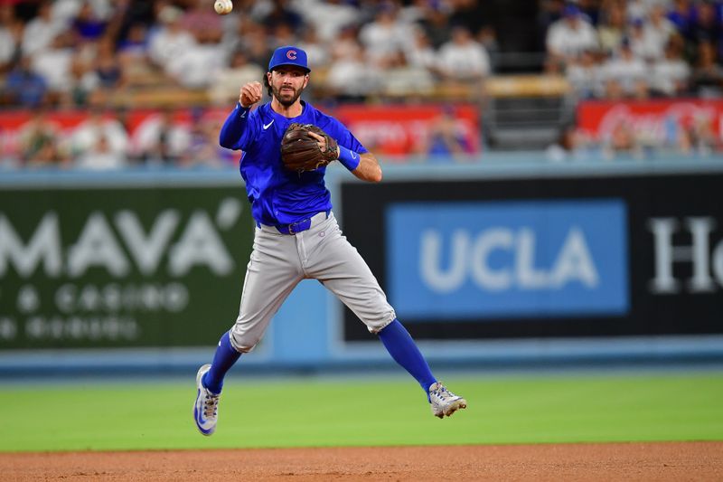 Sep 9, 2024; Los Angeles, California, USA; Chicago Cubs shortstop Dansby Swanson (7) throws to first for the out against Los Angeles Dodgers shortstop Miguel Rojas (11) during the third inning at Dodger Stadium. Mandatory Credit: Gary A. Vasquez-Imagn Images