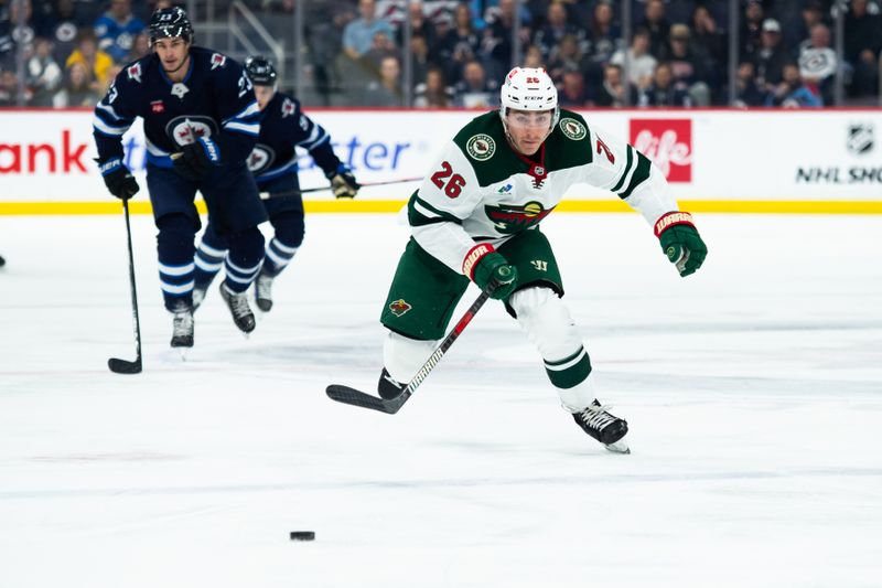 Feb 20, 2024; Winnipeg, Manitoba, CAN; Minnesota Wild forward Connor Dewar (26) chases the puck into the Winnipeg Jets zone during first period at Canada Life Centre. Mandatory Credit: Terrence Lee-USA TODAY Sports