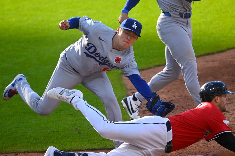 May 26, 2025; Cleveland, Ohio, USA; Los Angeles Dodgers starting pitcher Yoshinobu Yamamoto (18) tags out Cleveland Guardians second baseman Will Wilson (7) in the third inning at Progressive Field. Mandatory Credit: David Richard-Imagn Images