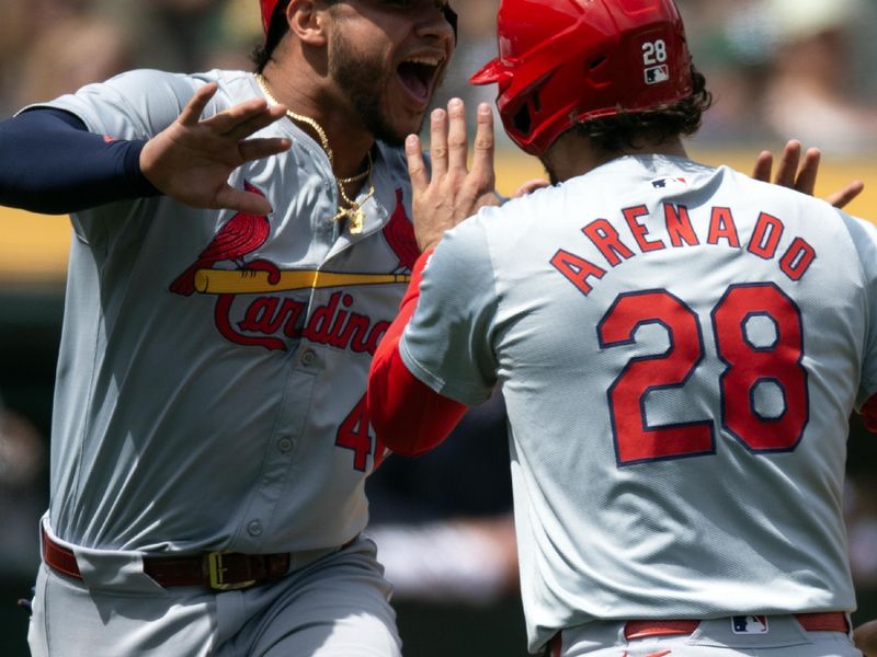Apr 17, 2024; Oakland, California, USA; St. Louis Cardinals designated hitter Willson Contreras (40) celebrates with teammate Nolan Arenado (28) as he scores on a single by Ivan Herrera during the fourth inning against the Oakland Athletics at Oakland-Alameda County Coliseum. Mandatory Credit: D. Ross Cameron-USA TODAY Sports