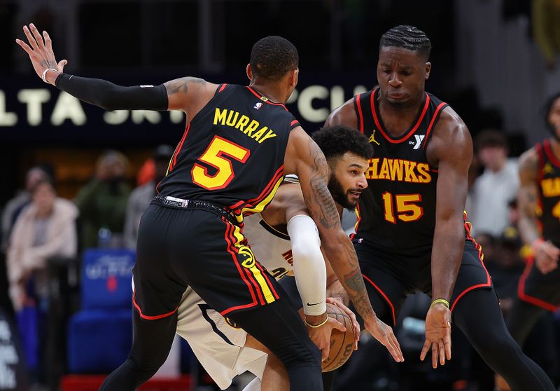 ATLANTA, GEORGIA - DECEMBER 11:  Dejounte Murray #5 and Clint Capela #15 of the Atlanta Hawks trap Jamal Murray #27 of the Denver Nuggets during the fourth quarter at State Farm Arena on December 11, 2023 in Atlanta, Georgia.  NOTE TO USER: User expressly acknowledges and agrees that, by downloading and/or using this photograph, user is consenting to the terms and conditions of the Getty Images License Agreement.  (Photo by Kevin C. Cox/Getty Images)