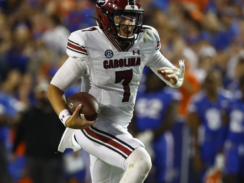 Nov 12, 2022; Gainesville, Florida, USA; South Carolina Gamecocks quarterback Spencer Rattler (7) runs with the ball against the Florida Gators during the second half at Ben Hill Griffin Stadium. Mandatory Credit: Kim Klement-USA TODAY Sports