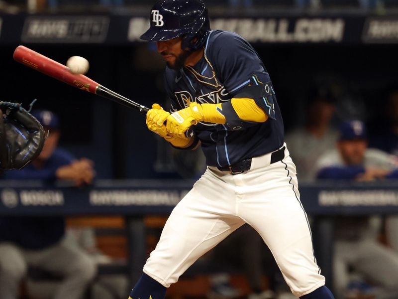 Apr 2, 2024; St. Petersburg, Florida, USA; Tampa Bay Rays shortstop Jose Caballero (7) gets hit by the pitch during the third inning against the Texas Rangers at Tropicana Field. Mandatory Credit: Kim Klement Neitzel-USA TODAY Sports