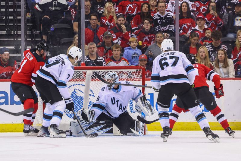 Oct 14, 2024; Newark, New Jersey, USA; New Jersey Devils center Nico Hischier (13) scores a goal on Utah Hockey Club goaltender Karel Vejmelka (70) during the third period at Prudential Center. Mandatory Credit: Ed Mulholland-Imagn Images