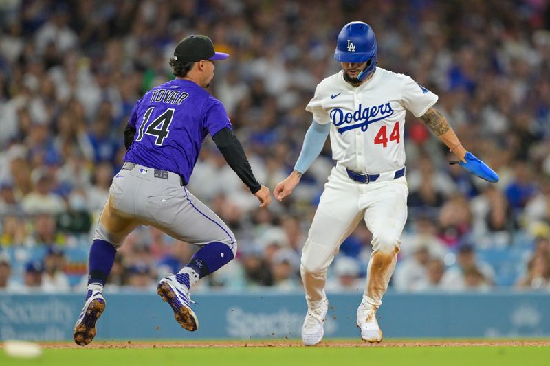 Sep 10, 2025; Los Angeles, California, USA; Colorado Rockies shortstop Ezequiel Tovar (14) misses the tag on Los Angeles Dodgers center fielder Andy Pages (44) on a rundown play in the fourth inning at Dodger Stadium. Mandatory Credit: Jayne Kamin-Oncea-Imagn Images