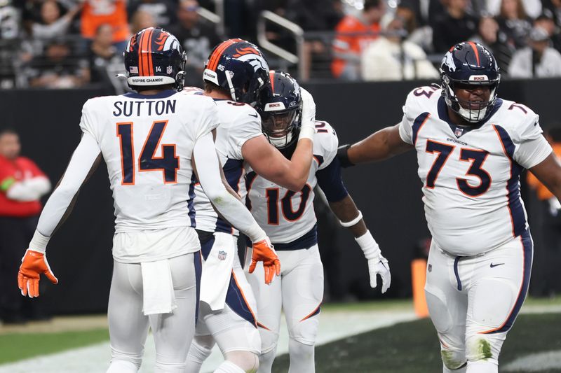 Denver Broncos palyers, from left, Courtland Sutton, Lucas Krull, Jerry Jeudy and Cam Fleming celebrate Jeudy's touchdown against the Las Vegas Raiders during the first half of an NFL football game, Sunday, Jan. 7, 2024 in Las Vegas. (AP Photo/Ellen Schmidt)