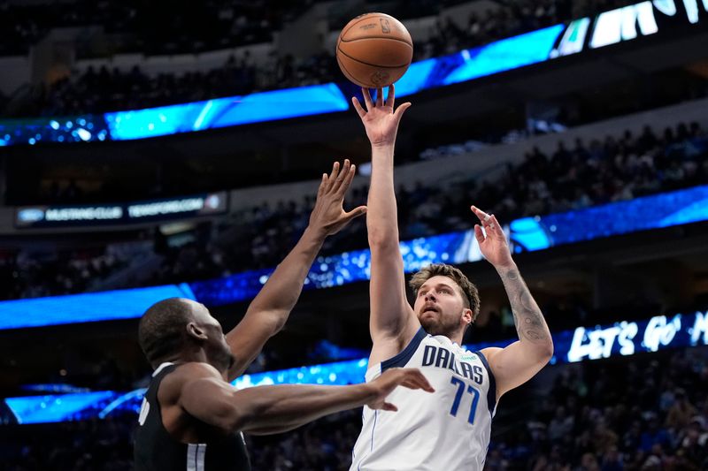 DALLAS, TEXAS - JANUARY 09: Luka Doncic #77 of the Dallas Mavericks shoots as Bismack Biyombo #18 of the Memphis Grizzlies defends during the first half at American Airlines Center on January 09, 2024 in Dallas, Texas. NOTE TO USER: User expressly acknowledges and agrees that, by downloading and or using this photograph, User is consenting to the terms and conditions of the Getty Images License Agreement. (Photo by Sam Hodde/Getty Images)