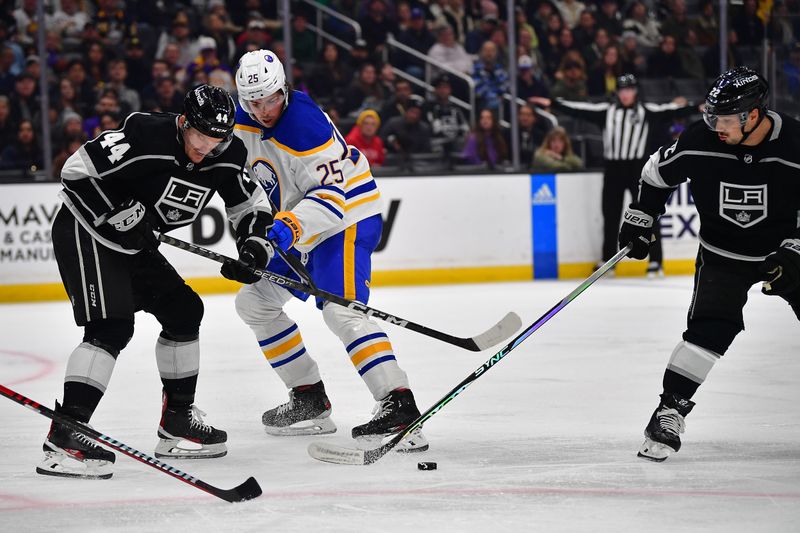 Feb 13, 2023; Los Angeles, California, USA; Los Angeles Kings defenseman Mikey Anderson (44) and left wing Kevin Fiala (22) play for the puck against Buffalo Sabres defenseman Owen Power (25) during the third period at Crypto.com Arena. Mandatory Credit: Gary A. Vasquez-USA TODAY Sports