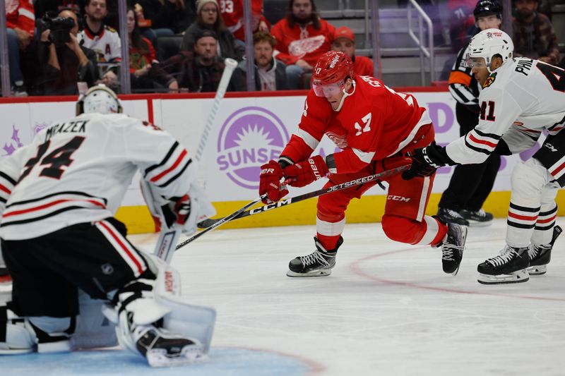 Nov 30, 2023; Detroit, Michigan, USA; Detroit Pistons guard Stanley Umude (17) skates with the puck defended by Chicago Blackhawks defenseman Isaak Phillips (41) in the second period at Little Caesars Arena. Mandatory Credit: Rick Osentoski-USA TODAY Sports