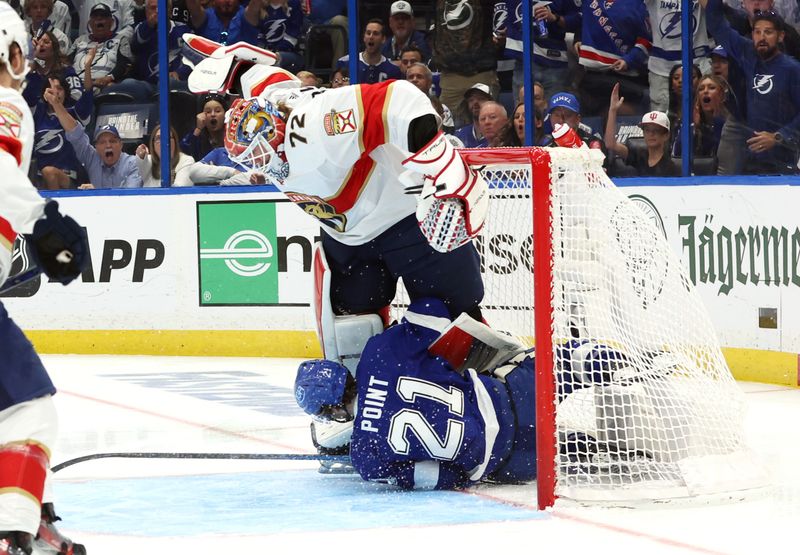 Apr 27, 2024; Tampa, Florida, USA; Tampa Bay Lightning center Brayden Point (21) slides into Florida Panthers goaltender Sergei Bobrovsky (72) after he was tripped during the first period in game four of the first round of the 2024 Stanley Cup Playoffs at Amalie Arena. Mandatory Credit: Kim Klement Neitzel-USA TODAY Sports