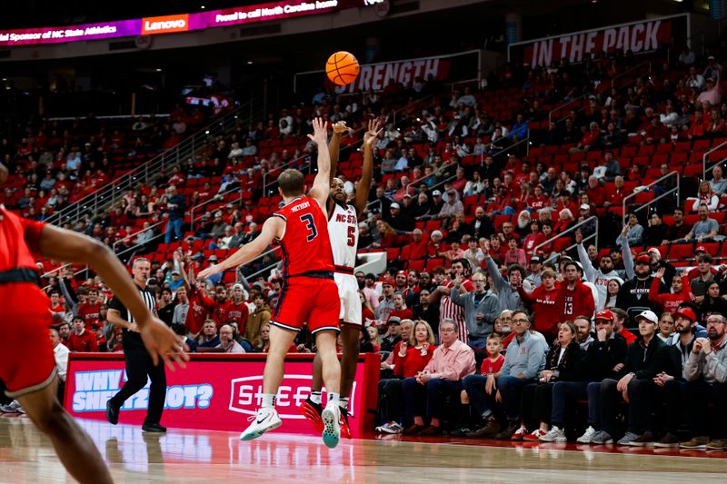 Dec 6, 2025; Raleigh, North Carolina, USA; NC State Wolfpack guard Tre Holloman (5) shoots a free throw past Liberty Flames guard Kaden Metheny (3) during the first half of the game  at Lenovo Center. Mandatory Credit: Jaylynn Nash-Imagn Images