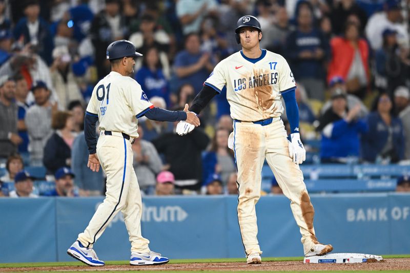 Sep 21, 2024; Los Angeles, California, USA; Los Angeles Dodgers designated hitter Shohei Ohtani (17) high fives Los Angeles Dodgers third base coach Dino Ebel (91) after stealing third base against the Colorado Rockies during the ninth inning at Dodger Stadium. Mandatory Credit: Jonathan Hui-Imagn Images