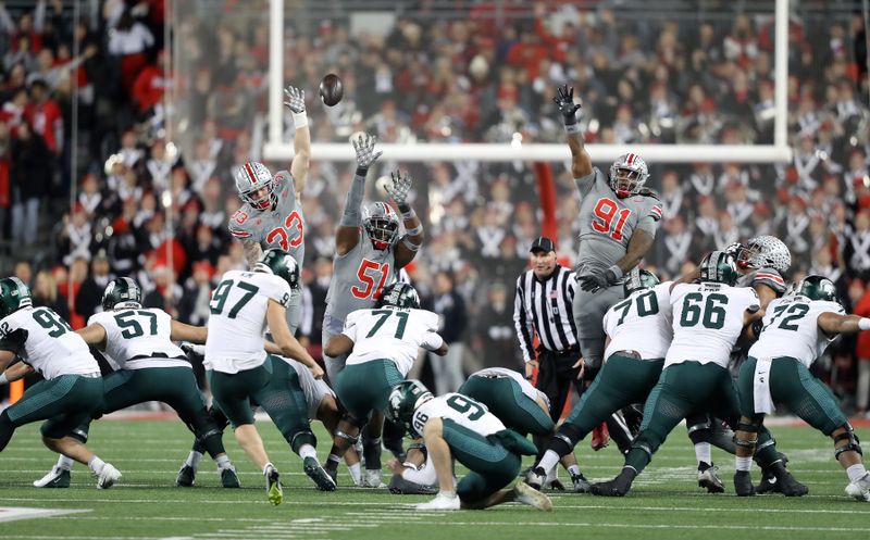 Nov 11, 2023; Columbus, Ohio, USA; Michigan State Spartans place kicker Jonathan Kim (97) attempts a field goal as Ohio State Buckeyes defensive end Jack Sawyer (33), defensive tackle Michael Hall Jr. (51), and defensive tackle Tyleik Williams (91) attempt a block during the first quarter at Ohio Stadium. Mandatory Credit: Joseph Maiorana-USA TODAY Sports