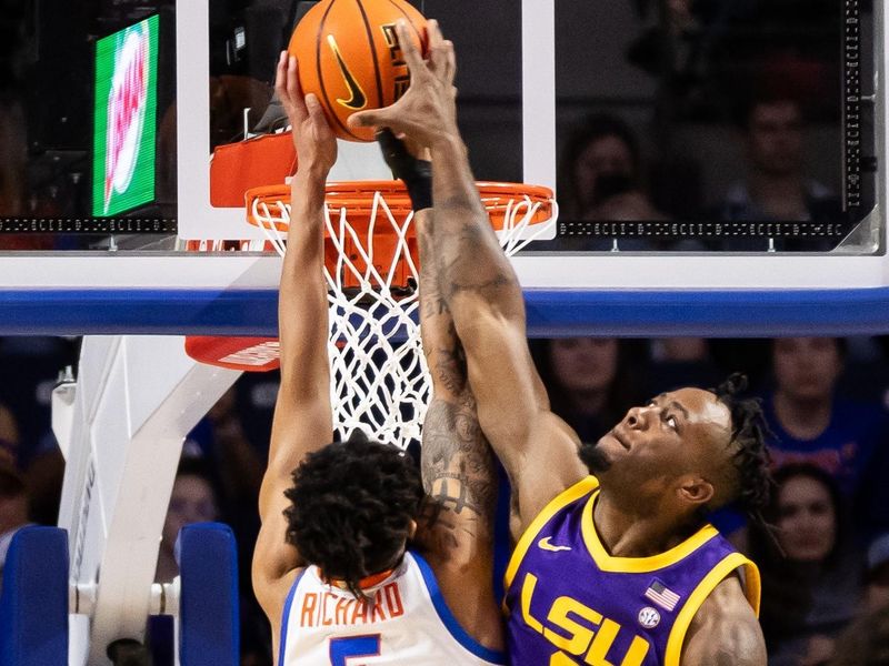 Feb 13, 2024; Gainesville, Florida, USA; LSU Tigers guard Trae Hannibal (0) attempts to block a dunk from Florida Gators guard Will Richard (5) during the first half at Exactech Arena at the Stephen C. O'Connell Center. Mandatory Credit: Matt Pendleton-USA TODAY Sports