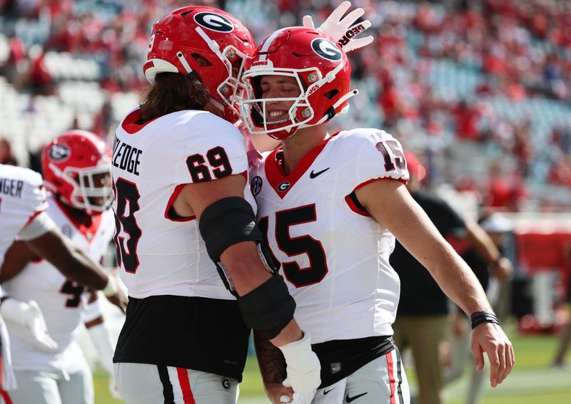 Oct 28, 2023; Jacksonville, Florida, USA; Georgia Bulldogs quarterback Carson Beck (15) and offensive lineman Tate Ratledge (69) hug prior to the game against the Florida Gators at EverBank Stadium. Mandatory Credit: Kim Klement Neitzel-USA TODAY Sports