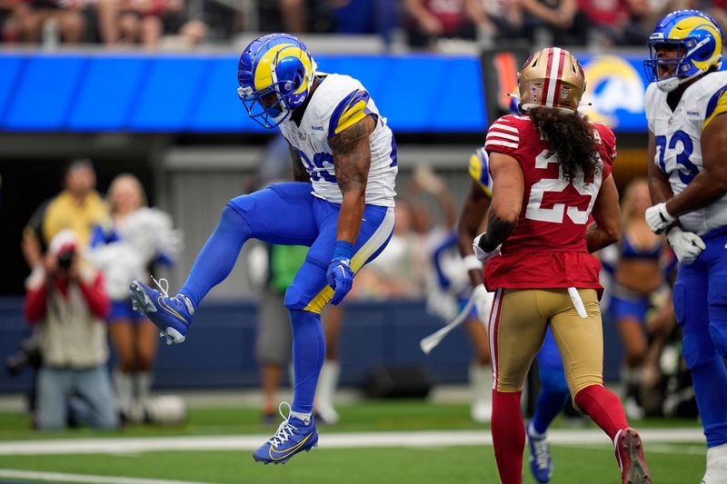 Los Angeles Rams running back Kyren Williams, left, scores a touchdown as guard Steve Avila, right, celebrates and San Francisco 49ers safety Talanoa Hufanga watches during the first half of an NFL football game Sunday, Sept. 17, 2023, in Inglewood, Calif. (AP Photo/Gregory Bull)