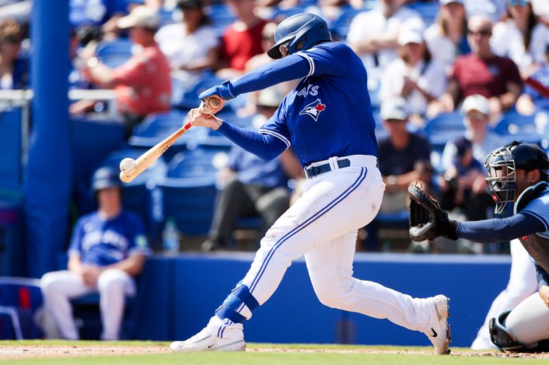 Feb 28, 2024; Dunedin, Florida, USA;  Toronto Blue Jays catcher Danny Jansen (9) hits a base hit against the Tampa Bay Rays in the first inning at TD Ballpark. Mandatory Credit: Nathan Ray Seebeck-USA TODAY Sports