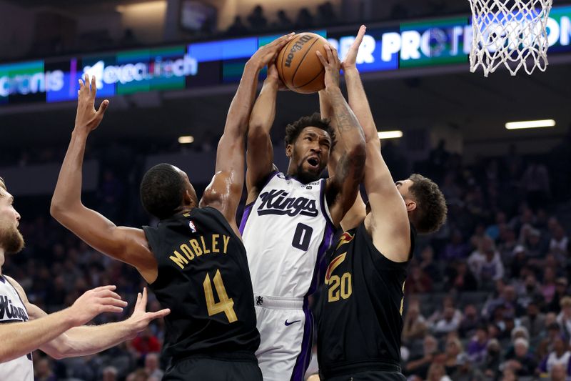 SACRAMENTO, CALIFORNIA - NOVEMBER 13: Malik Monk #0 of the Sacramento Kings goes up for a shot on Evan Mobley #4 and Georges Niang #20 of the Cleveland Cavaliers in the first half at Golden 1 Center on November 13, 2023 in Sacramento, California. NOTE TO USER: User expressly acknowledges and agrees that, by downloading and or using this photograph, User is consenting to the terms and conditions of the Getty Images License Agreement.  (Photo by Ezra Shaw/Getty Images)