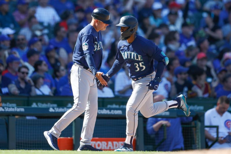 Apr 12, 2023; Chicago, Illinois, USA; Seattle Mariners right fielder Teoscar Hernandez (35) is congratulated by third base coach Manny Acta (14) as he rounds the bases after hitting a solo home run against the Chicago Cubs during the eight inning at Wrigley Field. Mandatory Credit: Kamil Krzaczynski-USA TODAY Sports