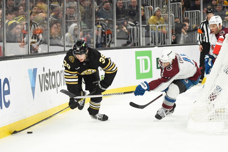 Jan 18, 2024; Boston, Massachusetts, USA; Boston Bruins center Morgan Geekie (39) controls the puck while Colorado Avalanche center Andrew Cogliano (11) defends during the third period at TD Garden. Mandatory Credit: Bob DeChiara-USA TODAY Sports
