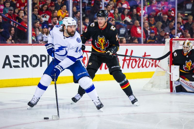 Jan 21, 2023; Calgary, Alberta, CAN; Tampa Bay Lightning left wing Pat Maroon (14) controls the puck in front of Calgary Flames defenseman Nikita Zadorov (16) during the first period at Scotiabank Saddledome. Mandatory Credit: Sergei Belski-USA TODAY Sports