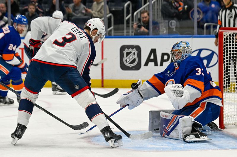 Nov 2, 2025; Elmont, New York, USA;  New York Islanders goaltender David Rittich (33) makes a save on Columbus Blue Jackets center Charlie Coyle (3) during the second period at UBS Arena. Mandatory Credit: Dennis Schneidler-Imagn Images