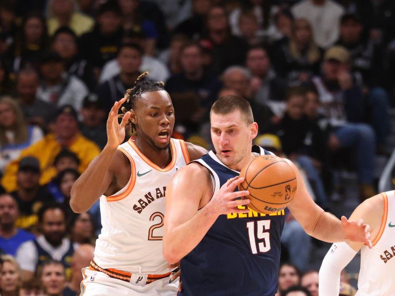 DENVER, COLORADO - NOVEMBER 26: Nikola Jokic #15 of the Denver Nuggets is defended by Charles Bassey #28 of the San Antonio Spurs in the first half at Ball Arena on November 26, 2023 in Denver, Colorado. NOTE TO USER: User expressly acknowledges and agrees that, by downloading and/or using this Photograph, user is consenting to the terms and conditions of the Getty Images License Agreement. (Photo by Justin Tafoya/Getty Images)