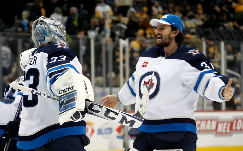 Jan 13, 2023; Pittsburgh, Pennsylvania, USA;  Winnipeg Jets goaltenders David Rittich (33) and Connor Hellebuyck (37) celebrate after defeating the Pittsburgh Penguins at PPG Paints Arena. The Jets won 4-1. Mandatory Credit: Charles LeClaire-USA TODAY Sports