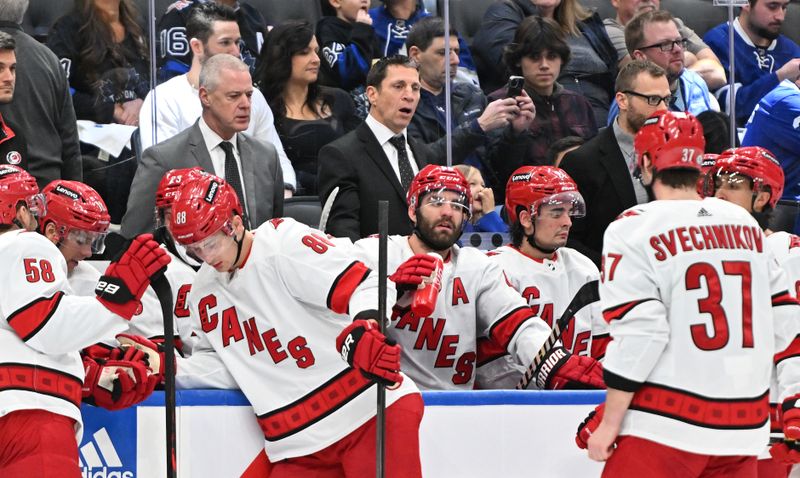 Dec 30, 2023; Toronto, Ontario, CAN; Carolina Hurricanes head coach Rod Brind'Amour speaks to his players as assistant coach Jeff Daniels looks on in the second period against the Toronto Maple Leafs at Scotiabank Arena. Mandatory Credit: Dan Hamilton-USA TODAY Sports