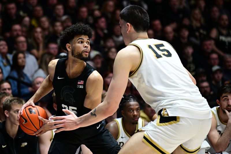 Mar 2, 2024; West Lafayette, Indiana, USA; Michigan State Spartans forward Malik Hall (25) looks to get the ball past Purdue Boilermakers center Zach Edey (15) during the first half at Mackey Arena. Mandatory Credit: Marc Lebryk-USA TODAY Sports