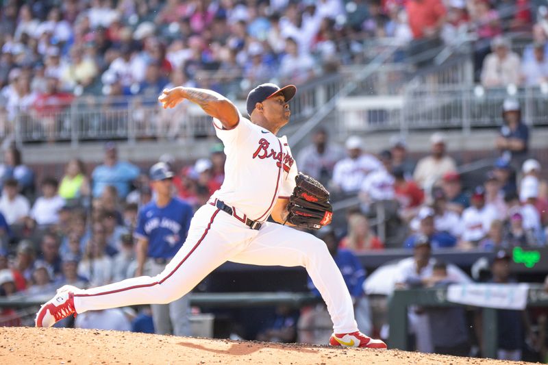 Sep 8, 2024; Cumberland, Georgia, USA; Atlanta Braves pitcher Raisel Iglesias (26) pitches the ball against the Toronto Blue Jays during the eleventh inning at Truist Park. Mandatory Credit: Jordan Godfree-Imagn Images