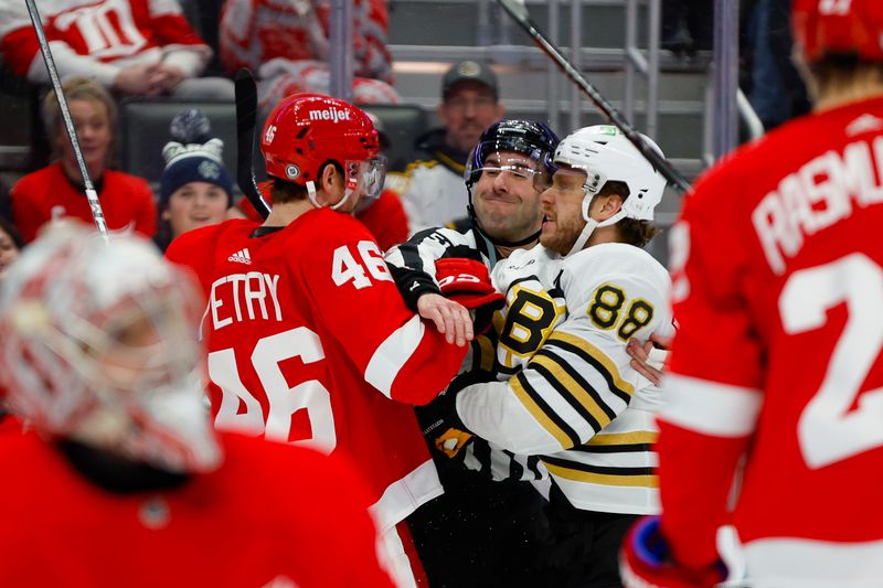 Dec 31, 2023; Detroit, Michigan, USA; Detroit Red Wings defenseman Jeff Petry (46) scuffles with Boston Bruins right wing David Pastrnak (88) while linesman Andrew Smith (51) tries to separate them during the first period of the game between the Boston Bruins and the Detroit Red Wings at Little Caesars Arena. Mandatory Credit: Brian Bradshaw Sevald-USA TODAY Sports