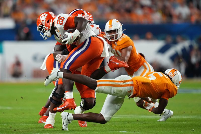 Dec 30, 2022; Miami Gardens, FL, USA; Clemson Tigers running back Phil Mafah (26) runs the ball past Tennessee Volunteers defensive back Kamal Hadden (5) during the first half of the 2022 Orange Bowl at Hard Rock Stadium. Mandatory Credit: Jasen Vinlove-USA TODAY Sports