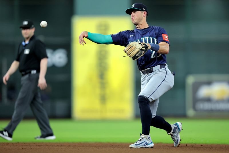 May 22, 2025; Houston, Texas, USA; Seattle Mariners second baseman Dylan Moore (25) throws a fielded ball to first base for an out against the Houston Astros during the fourth inning at Daikin Park. Mandatory Credit: Erik Williams-Imagn Images