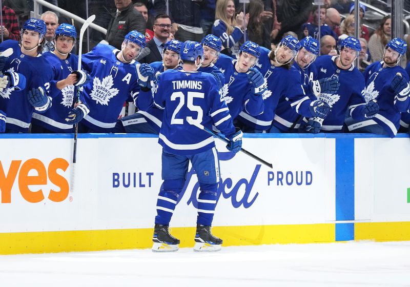 Nov 9, 2024; Toronto, Ontario, CAN; Toronto Maple Leafs defenseman Conor Timmins (25) celebrates at the bench after scoring a goal against the Montreal Canadiens during the first period at Scotiabank Arena. Mandatory Credit: Nick Turchiaro-Imagn Images