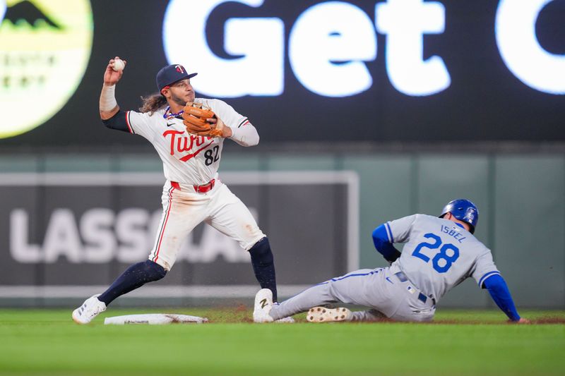 Aug 12, 2024; Minneapolis, Minnesota, USA; Minnesota Twins second base Austin Martin (82) throws to first base against the Kansas City Royals outfielder Kyle Isbel (28) in the seventh inning at Target Field. Mandatory Credit: Brad Rempel-USA TODAY Sports