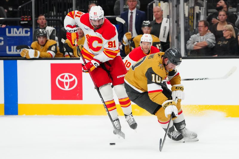 Oct 18, 2025; Las Vegas, Nevada, USA; Calgary Flames center Nazem Kadri (91) evades the check of Vegas Golden Knights center Colton Sissons (10) during the first period at T-Mobile Arena. Mandatory Credit: Stephen R. Sylvanie-Imagn Images