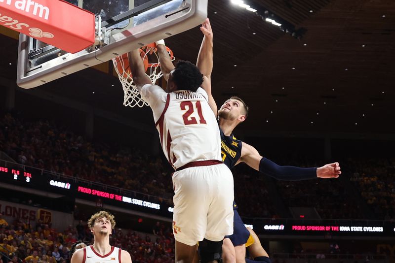 Feb 27, 2023; Ames, Iowa, USA; Iowa State Cyclones center Osun Osunniyi (21) scores in front of West Virginia Mountaineers guard Erik Stevenson (10) during the second half at James H. Hilton Coliseum. Mandatory Credit: Reese Strickland-USA TODAY Sports