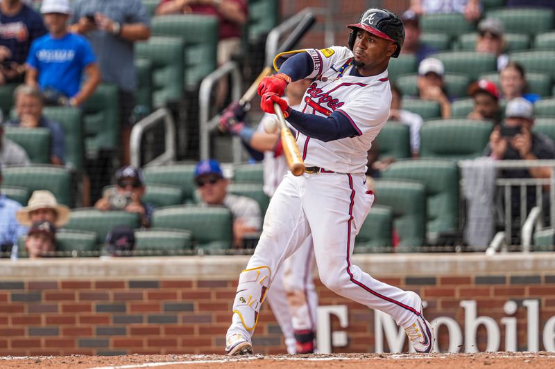 Jul 20, 2024; Cumberland, GA, USA; Atlanta Braves second baseman Ozzie Albies (1) hits a game winning sacrifice fly ball against the St. Louis Cardinals during the tenth inning at Truist Park. Mandatory Credit: Dale Zanine-USA TODAY Sports