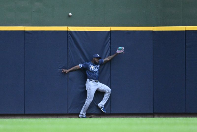 May 1, 2024; Milwaukee, Wisconsin, USA; Tampa Bay Rays outfielder Randy Arozarena (56) runs into the wall as he attempts to catch a home run ball in the seventh inning at American Family Field. Mandatory Credit: Michael McLoone-USA TODAY Sports
