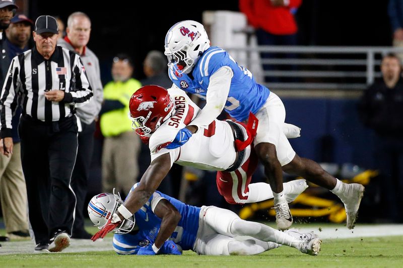 Oct 7, 2023; Oxford, Mississippi, USA; Arkansas Razorbacks running back Raheim Sanders (5) is tackled by Mississippi Rebels defensive back Zamari Walton (6) and linebacker Khari Coleman (23) during the first half at Vaught-Hemingway Stadium. Mandatory Credit: Petre Thomas-USA TODAY Sports