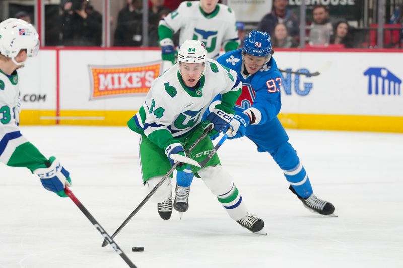 Jan 3, 2026; Raleigh, North Carolina, USA; Carolina Hurricanes right wing Jackson Blake (53) skates with the puck against Colorado Avalanche center Zakhar Bardakov (93) during the first period at Lenovo Center. Mandatory Credit: James Guillory-Imagn Images