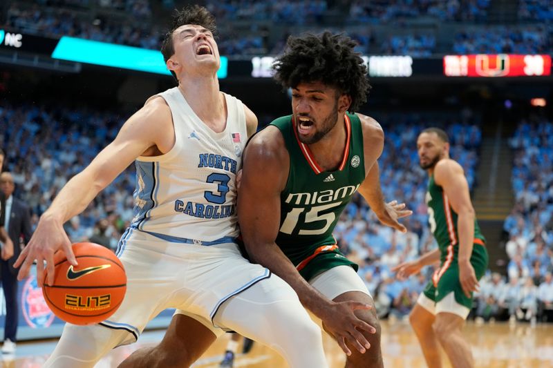 Feb 26, 2024; Chapel Hill, North Carolina, USA; North Carolina Tar Heels guard Cormac Ryan (3) with the ball as Miami (Fl) Hurricanes forward Norchad Omier (15) defends in the second half at Dean E. Smith Center. Mandatory Credit: Bob Donnan-USA TODAY Sports